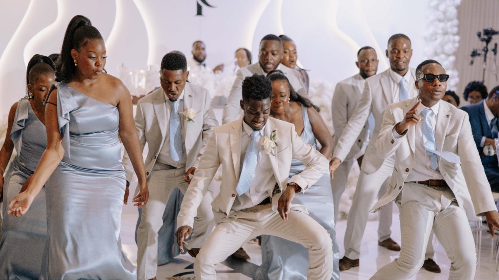 Groomsmen and bridesmaids dancing in blue and beige