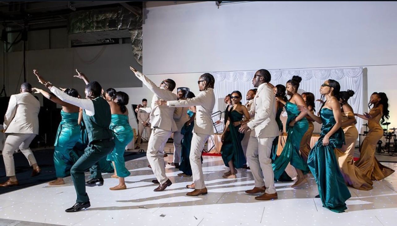 Bridal party with arms raised in unison